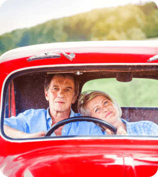 senior-couple-in-their-vintage-red-car